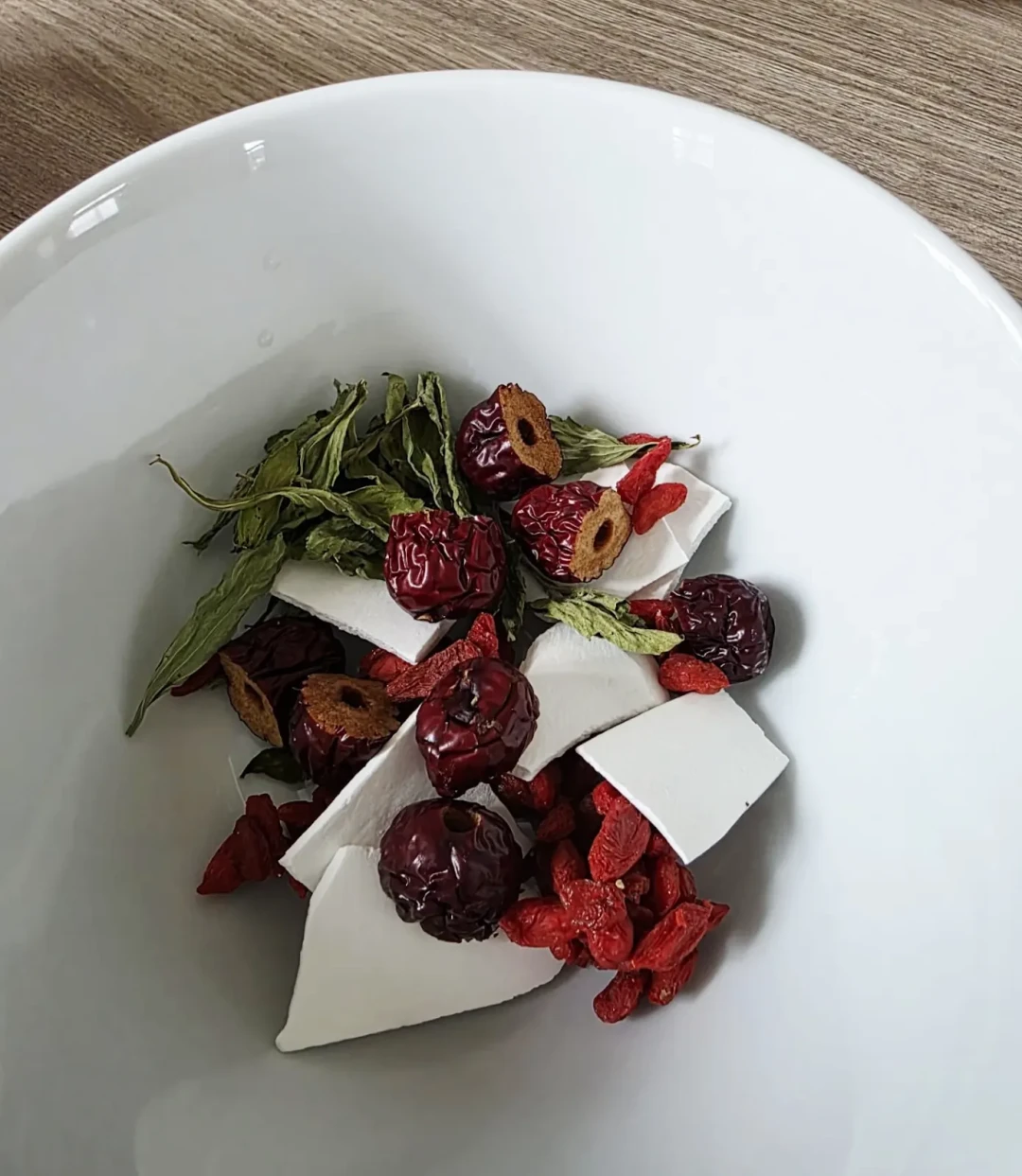 Dried ingredients for Elle's tea blend in a white bowl.