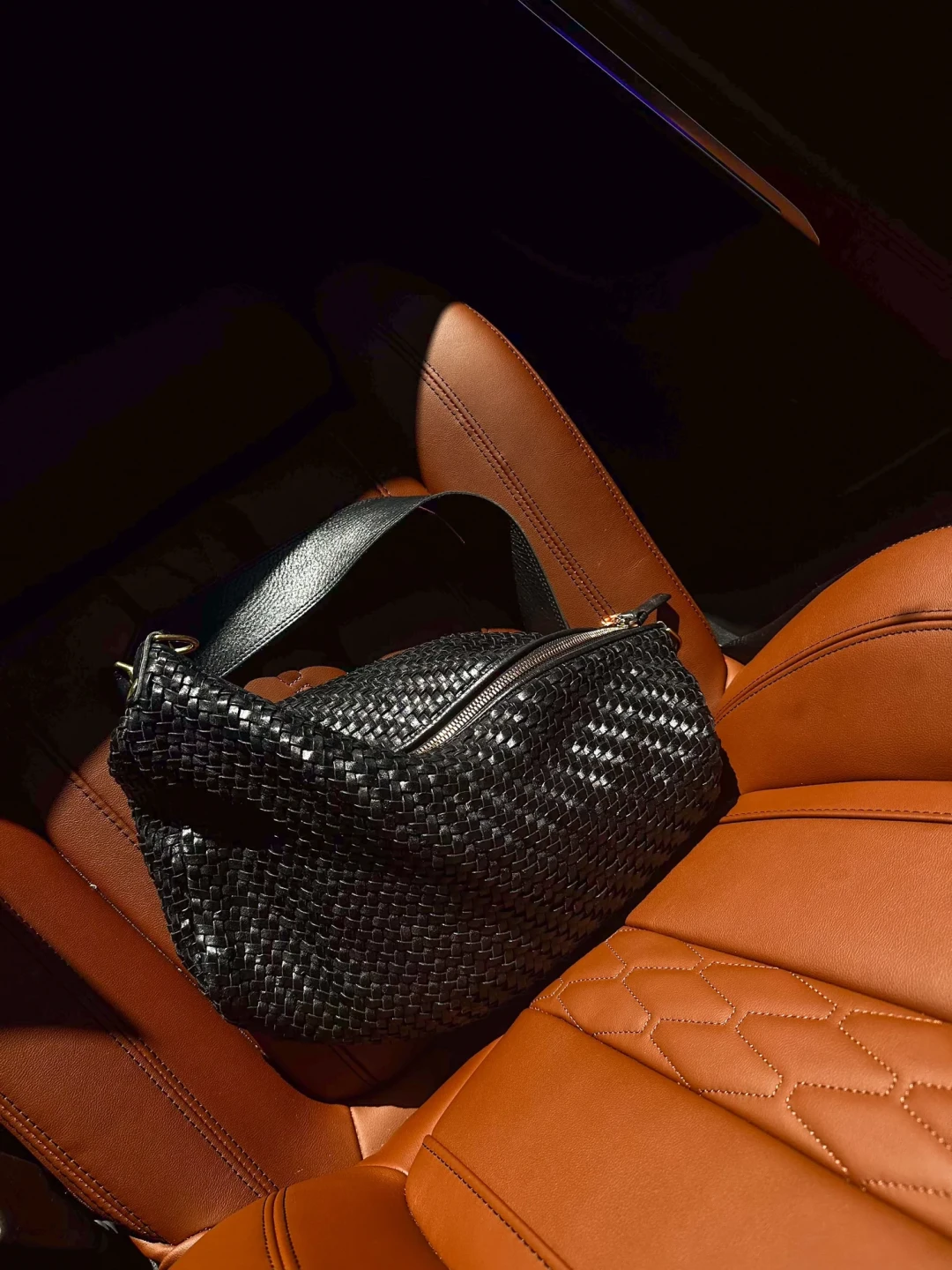 Woven leather handbag in a car