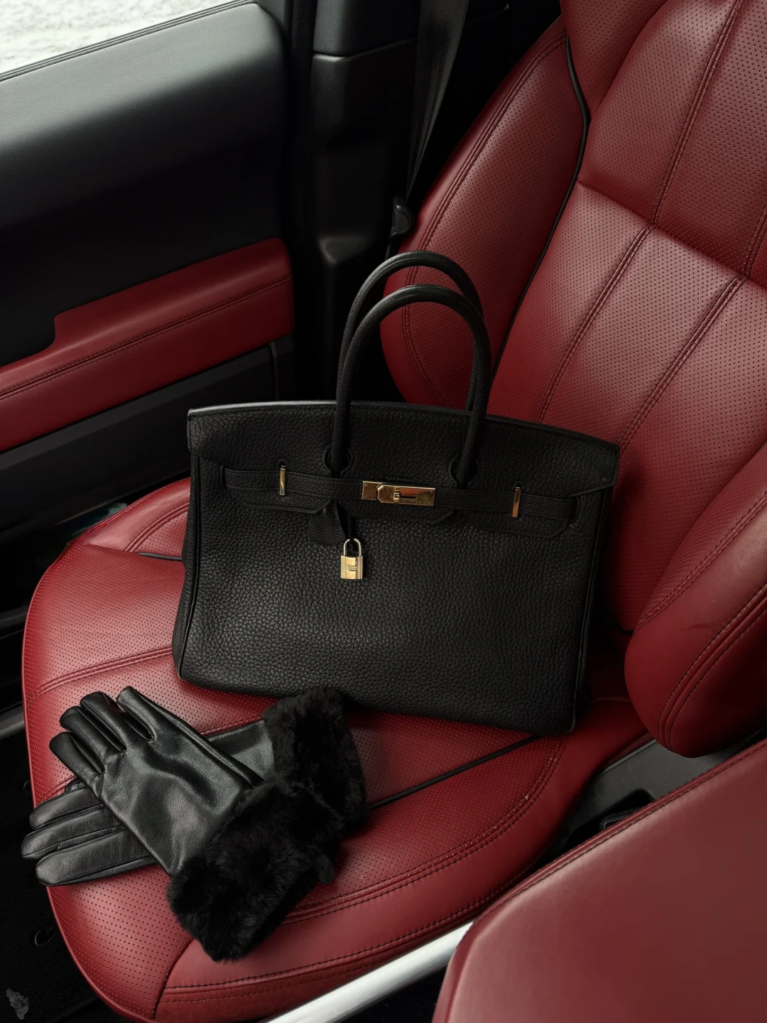 Black leather handbag in a car
